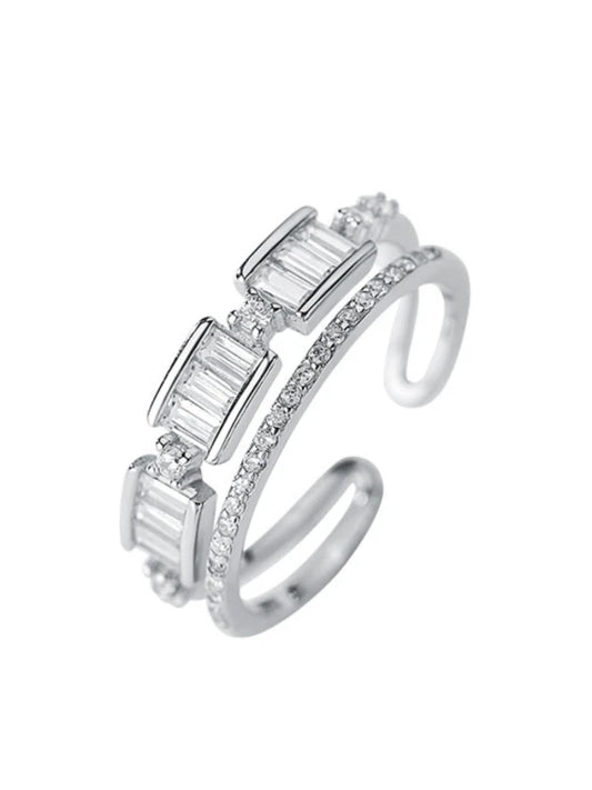 Silver ring with baguette-cut gemstones on a white background