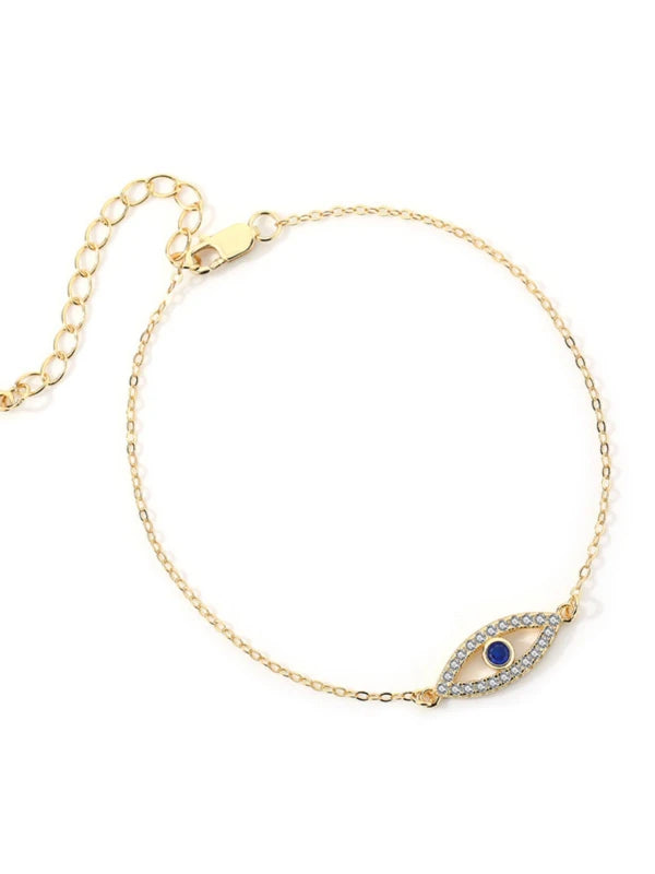 Gold bracelet with a blue eye design on a white background