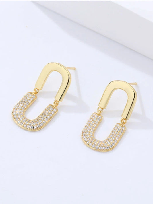 Gold earrings with diamond-like stones on a white background
