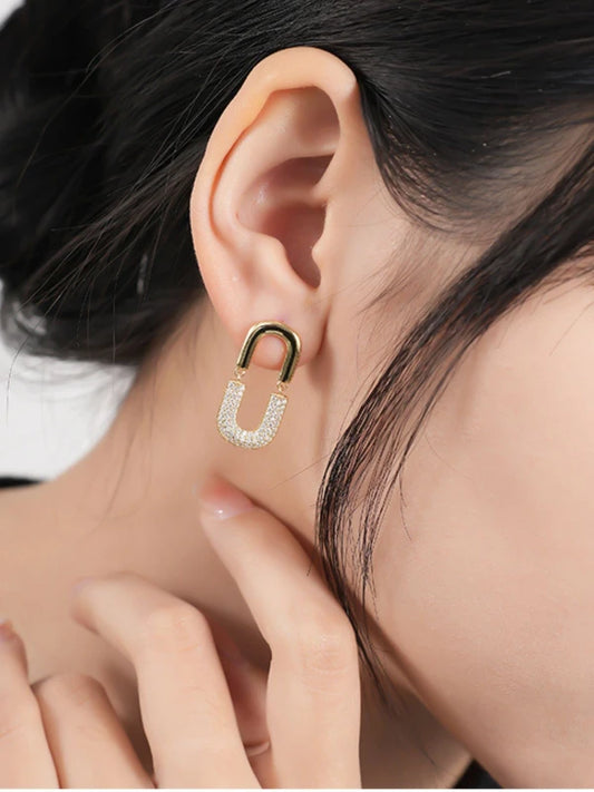 Gold and diamond earring worn by a woman