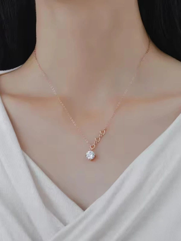 Necklace with a diamond pendant worn by a woman in a white top