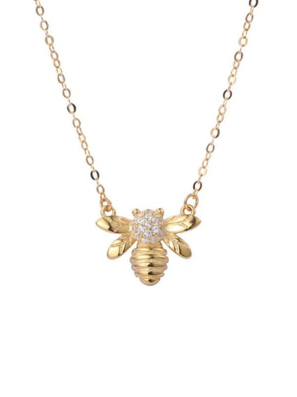 Gold bee-shaped necklace with a diamond on a white background