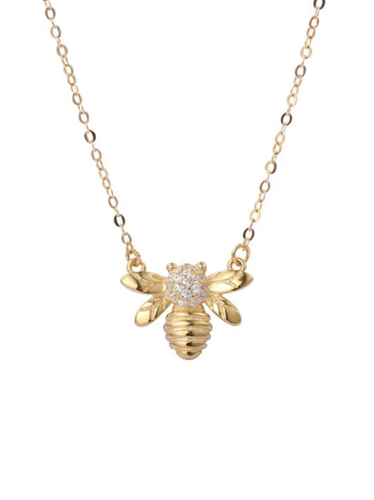 Gold bee-shaped necklace with a diamond on a white background