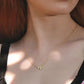 Close-up of a woman wearing a honey bee pendant necklace with a small pendant.