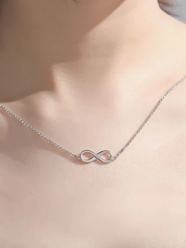 Silver infinity necklace on a woman's neck