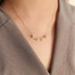 Gold necklace worn by a woman.