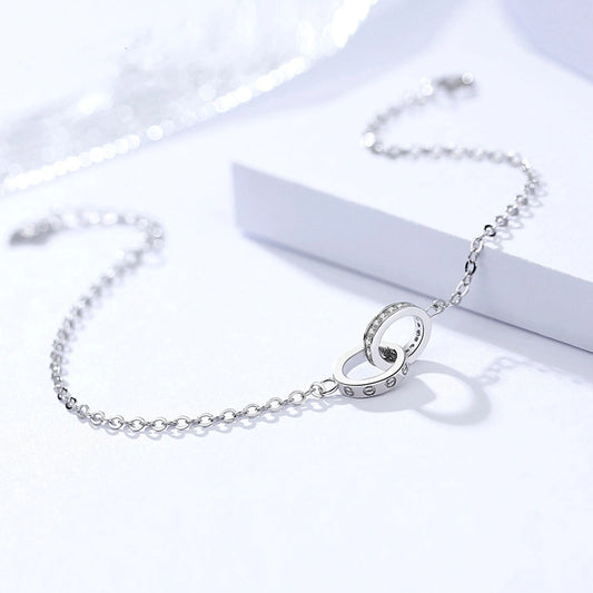 Silver bracelet with a circular clasp on a white background