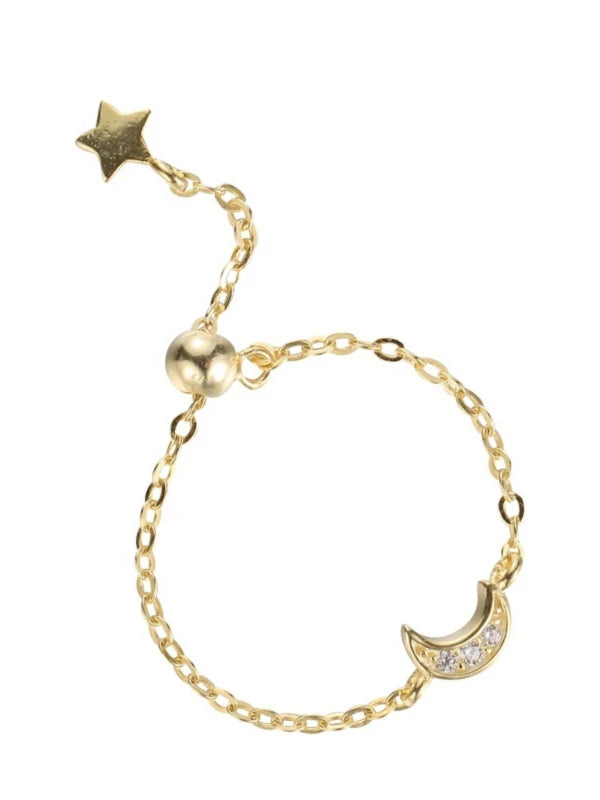 Gold bracelet with star and moon charm on a white background