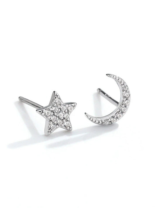 Silver star and moon earrings on a white background