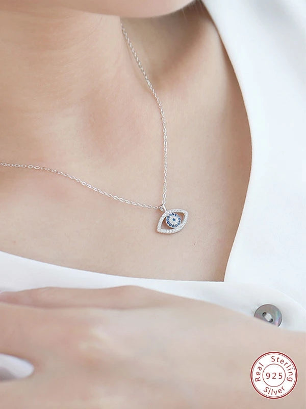Silver necklace with a heart-shaped pendant worn by a woman.