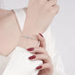 Hand wearing a silver bracelet on a white background
