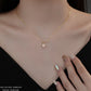 Gold necklace with a heart-shaped pendant on a woman's neck.