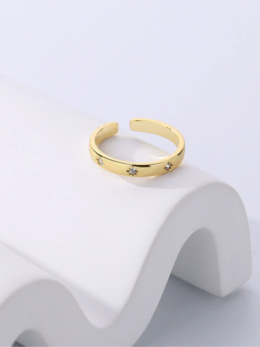 Gold ring with star designs on a white background