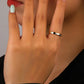 Close-up of a hand with a ring on a neutral background