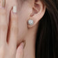 Close-up of a woman wearing a diamond stud earring with a blurred background