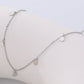 Silver necklace with round pendants on a light gray background