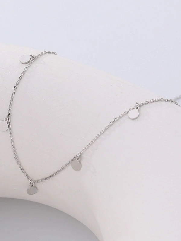 Silver necklace with round pendants on a light gray background