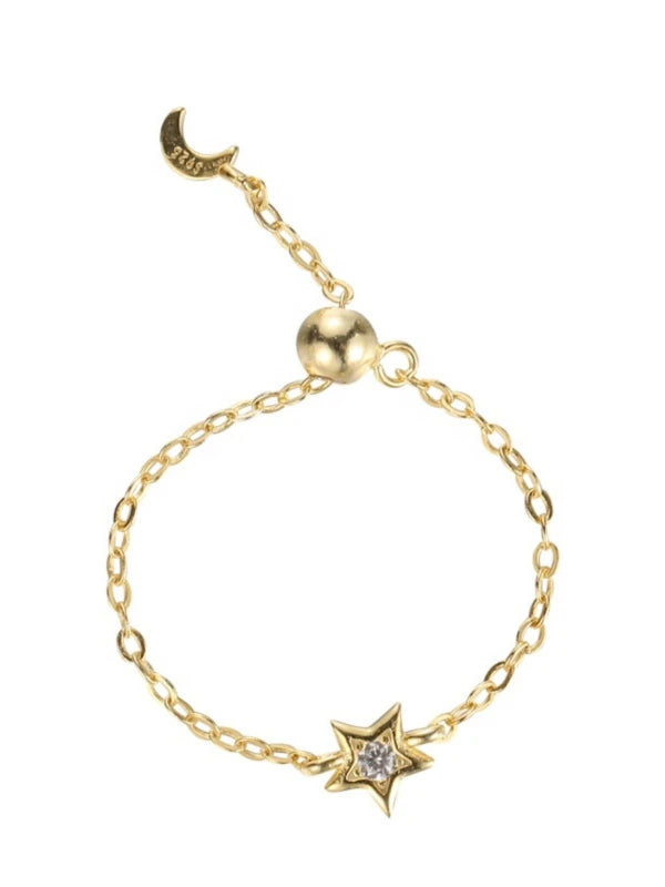 Gold bracelet with star and moon charm on a white background
