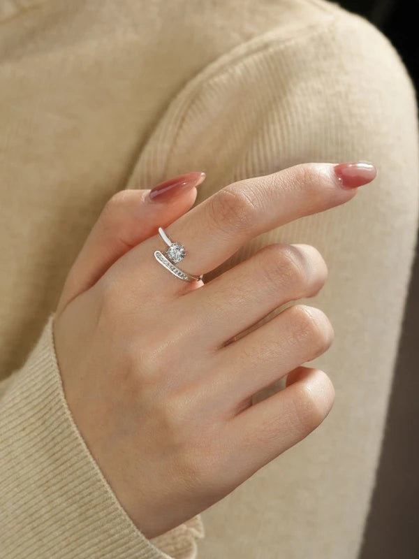 Close-up of a hand wearing a diamond ring with a blurred background