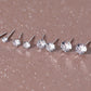 Set of silver stud earrings on a glittery brown surface