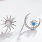 Silver sun and moon earrings with gemstones on a white background