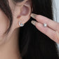 Close-up of a woman wearing a silver earring with a blue gemstone.