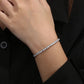 Silver bracelet on a person's wrist with a blurred background