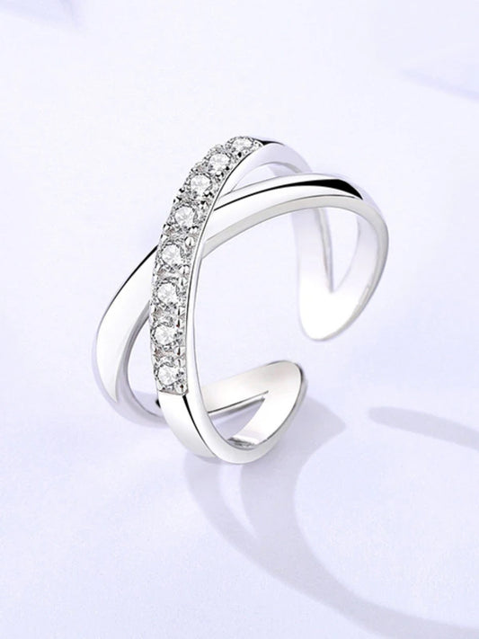 Silver ring with diamond accents on a light gray background