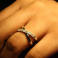 Close-up of a hand wearing a diamond ring with a dark background