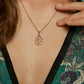 Gold necklace with a tree of life pendant worn by a woman