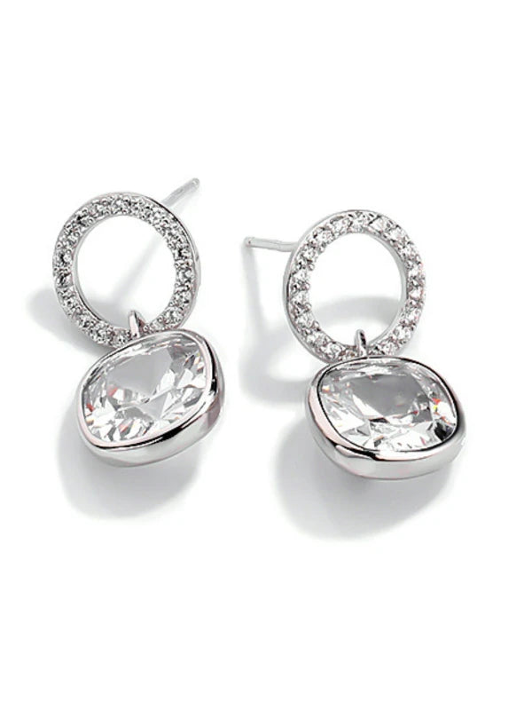 Silver earrings with clear gemstones on a white background