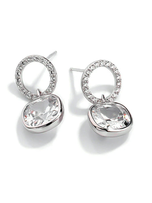 Silver earrings with clear gemstones on a white background