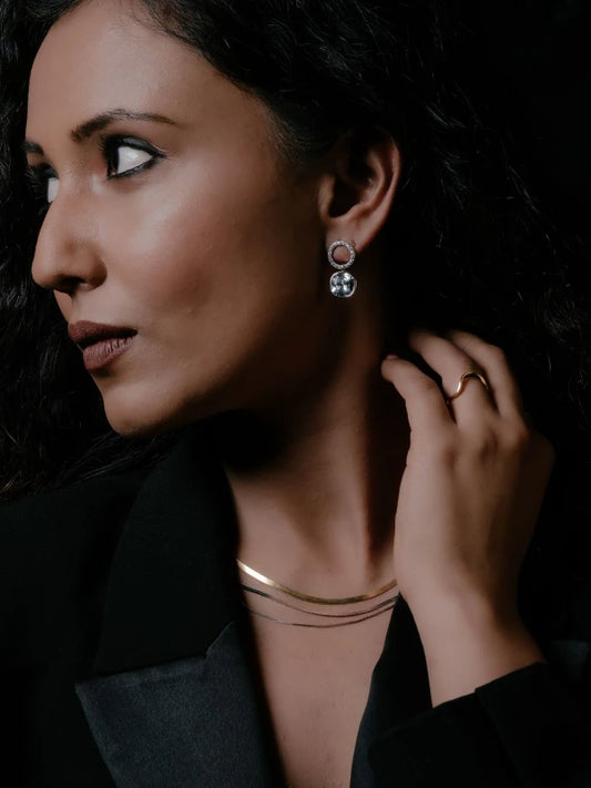 Woman wearing earrings with a dark background