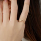 Hand wearing a gold ring with hair in the background
