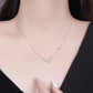 Necklace with butterfly pendants worn by a woman against a neutral background